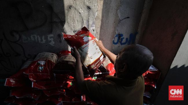 Warga membawa Bantuan Sosial (Bansos) dari Pemprov DKI Jakarta untuk penanganan COVID-19. (CNN Indonesia/ Adhi Wicaksono)