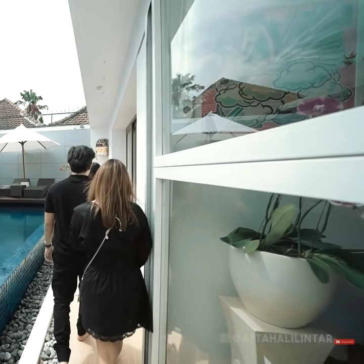 <p>Rumah Maharani dan Ajik Gede dirancang memiliki kolam renang yang terletak di bagian tengah. Model infinity pool itu membuat suasana rumah terlihat semakin modern. (Foto: YouTube AH)</p>
