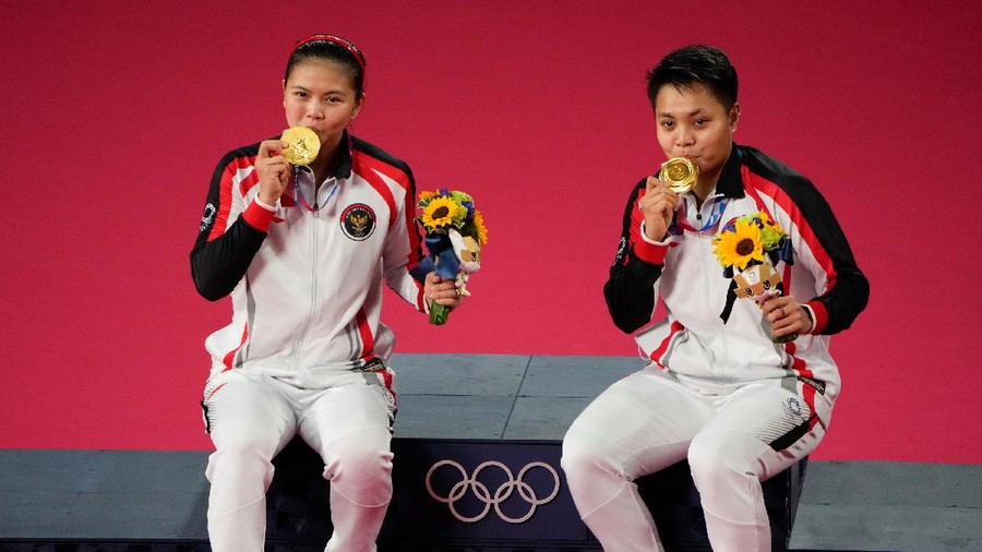 Gold medalists Greysia Polii, left, and Apriyani Rahayu from Indonesia celebrate during the medals ceremony of the women's doubles gold medal match at the 2020 Summer Olympics, Monday, Aug. 2, 2021, in Tokyo, Japan. (AP Photo/Markus Schreiber)