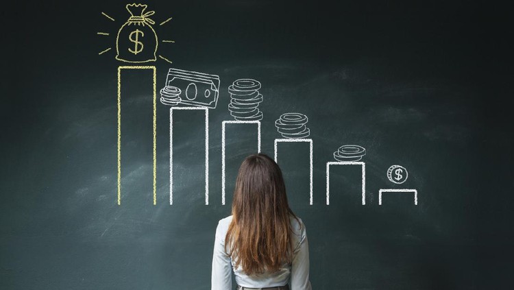Business woman standing in front of a blackboard with a financial chart