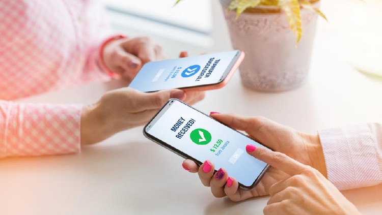Ilustrasi pinjam atau transfer uang Woman sending money to her friend using mobile phone