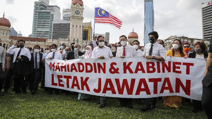 Anggota oposisi Malaysia melakukan aksi dengan memegang spanduk bertuliskan Malaysian opposition members Anwar Ibrahim, fourth from left, and Mahathir Mohamad, second from left in blue mask, hold a banner reading