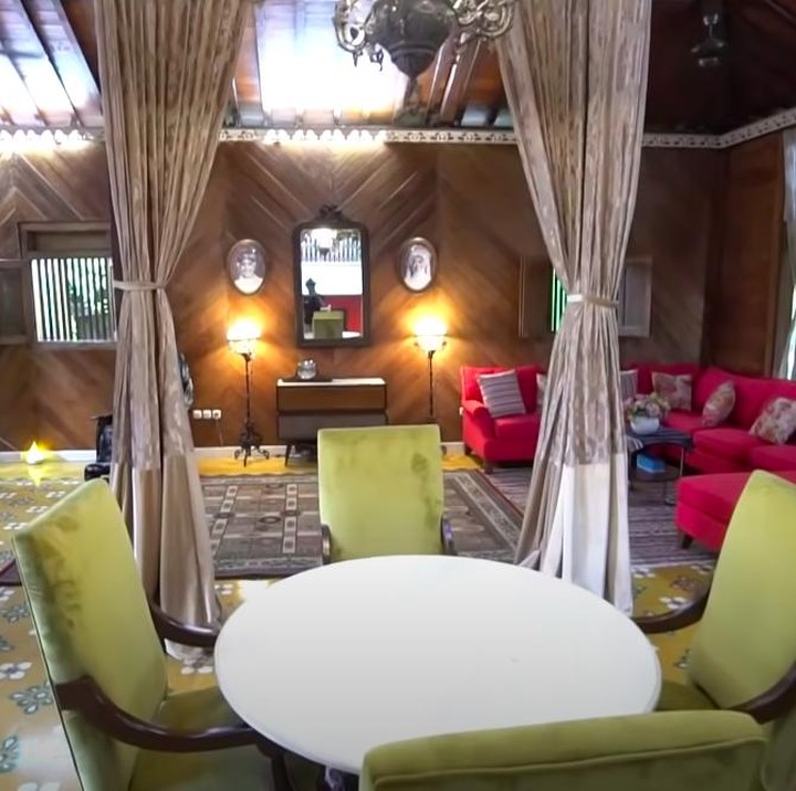 <p>Ruang tamu rumah Irfan Hakim cukup luas nih. Selain ornamen kayu, pria 45 tahun ini juga menambahkan aksen modern dengan sofa berwarna hijau dan merah di dalam ruangan. (Foto: YouTube Ricis Official)</p>