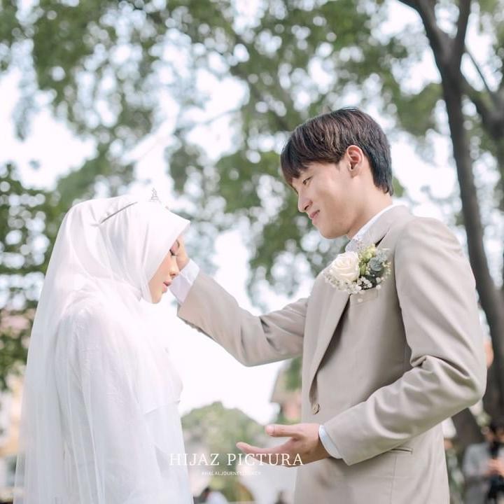<p>Juli dan Daehoon tampak masih malu-malu nih, Bunda. Meski begitu, kemesraan pun tetap terlihat di hari pertama keduanya mengikat janji suci. (Foto: Instagram: @hijazpictura)</p>