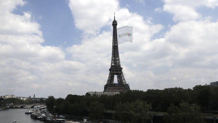 FILE - In this June 8, 2021, file photo, a giant flag flies at the Eiffel Tower during a a test flight in Paris. A giant flag will be flown from the Eiffel Tower like this one on Sunday, Aug. 8, during the Tokyo Olympics closing ceremony that 2024 Paris Olympics organizers claim will be the biggest ever seen. (AP Photo/Lewis Joly, File)