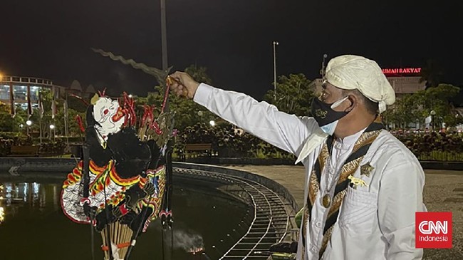 Nuryanto membakar dupa dan hio di depan sesaji berupa bunga tujuh rupa, bunga tiga jenis atau kembang telon, teh, kopi, air putih, kelapa hijau dan buah.