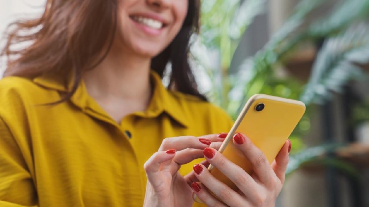 Cropped image of happy girl using smartphone device while chilling at home