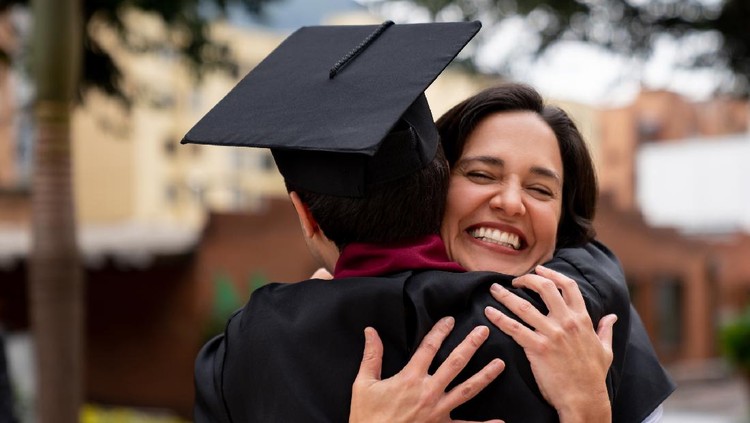Proud mother hugging her graduating son and looking very happy â education concepts