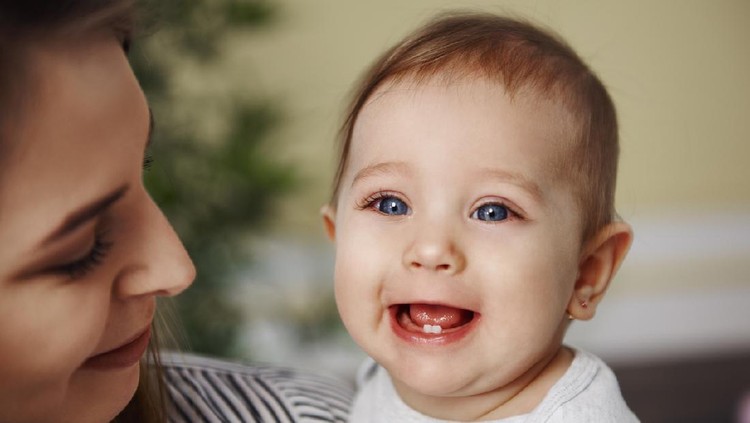 Cute baby girl showing her primary teeth