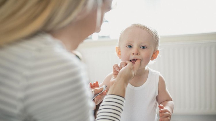 Cute baby girl showing her primary teeth