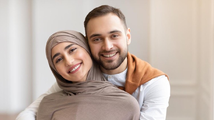 pasangan muslim Awaiting Baby. Joyful Muslim Couple Holding Positive Pregnancy Test Sitting Together On Sofa Indoors, Focus On Test. Happy Parents-To-Be, Childbirth Concept. Shallow Depth, Cropped