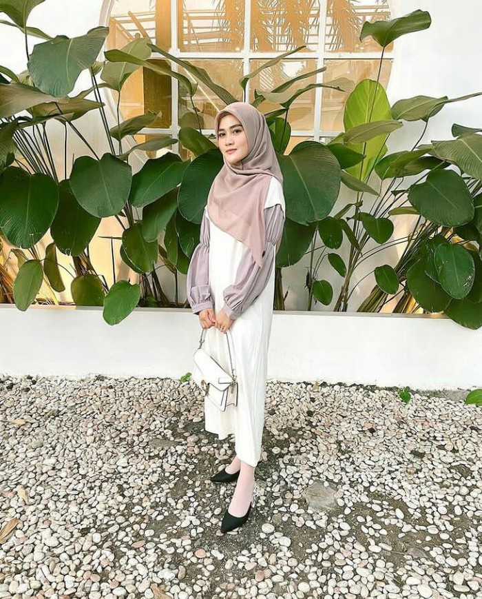 Memakai long blouse dan hand bag putih, terlihat simpel namun tetap tampil cantik. Bisa kamu jadikan inspirasi gaya hangout bersama teman usai PPKM atau pandemi kelar, nih. /Foto: instagram.com/hennyyrahman