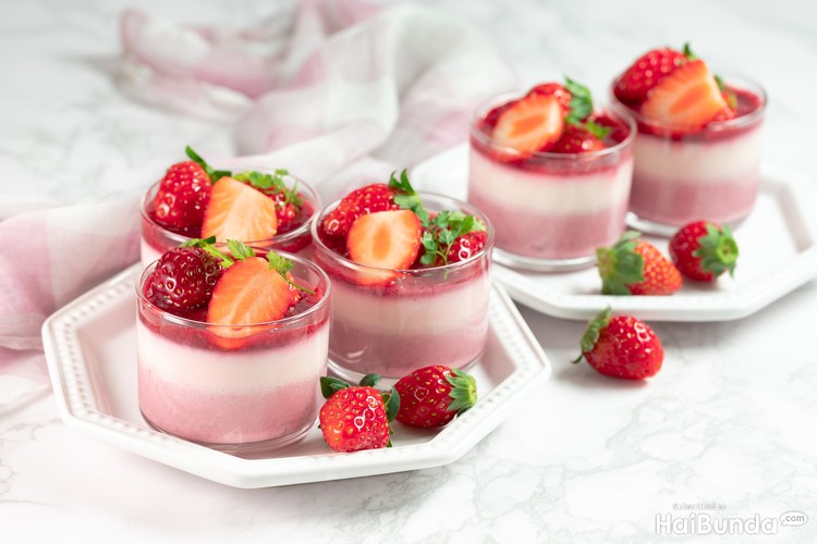 puding merah putih Traditional italian dessert vanilla strawberry panna cotta in a glass with fresh berries on a marble background.