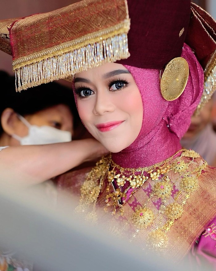 Mengenakan baju adat Minang, ini potret Lesti ketika melangsungkan malam Bainai, yang merupakan acara pranikah khas adat Minang. Malam Bainai itu sendiri merupakan malam terakhir bagi calon pengantin perempuan Minangkabau, untuk merasakan kebebasan sebagai perempuan lajang. /Foto: instagram.com/@jatupurwanti