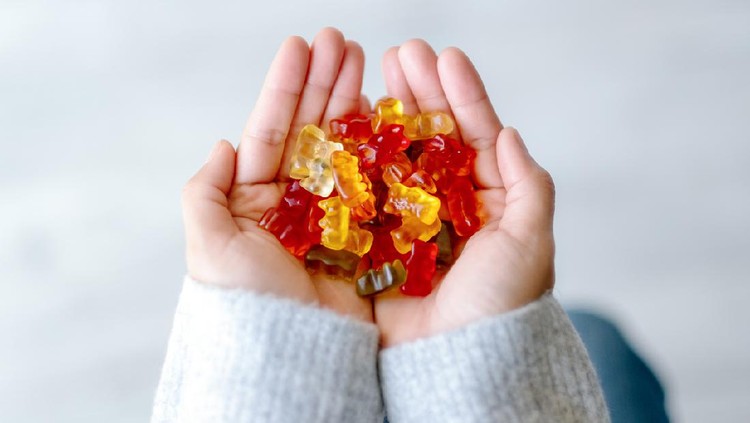 Ilustrasi Juice Gummy Top view image of a woman holding colorful Jelly gum in hands