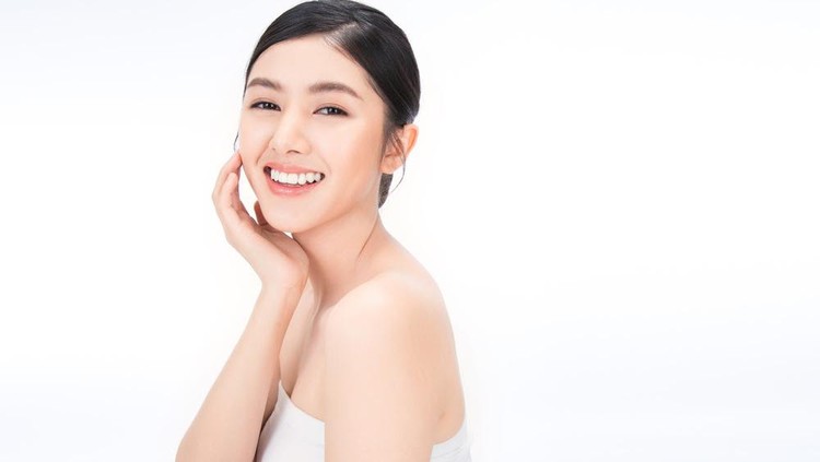 portrait of beauty asian woman with fair perfect healthy glow skin hand touching chin on white background, young beautiful asia girl with pretty smile face care. Beauty korean spa skincare.