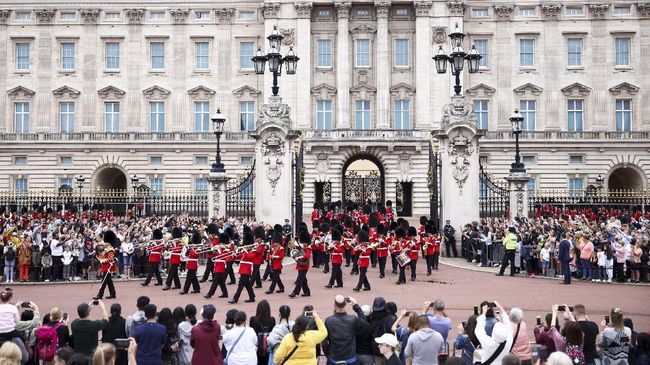 Wajah-wajah ceria terlihat dalam Upacara Pergantian Penjaga yang kembali digelar di Istana Buckingham, London, Inggris.