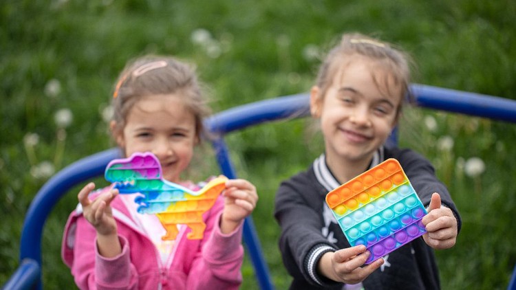 Little girls playing a new fidget toy popular with children helps them to concentrate.
