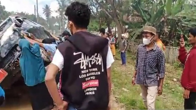 Sekelompok ibu-ibu dibantu sejumlah pria menggoyangkan sebuah mobil dinas hingga nyaris terguling sebagai bentuk protes jalan rusak di Muna, Sulawesi Tenggara.
