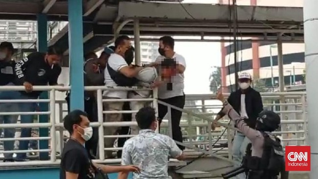 Seorang yang terluka dalam kericuhan pasca sidang putusan banding FPI Rizieq Shihab mengenakan baju berwarna putih bertulisan #2019KomandoHabibRizieqSyihab.