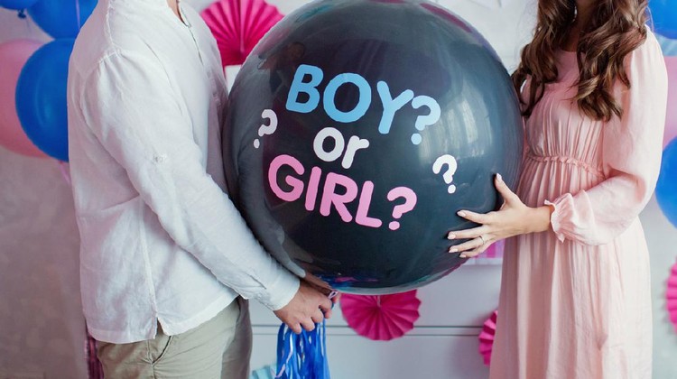 Boy or Girl text surrounded with pastel colored feathers, Gender reveal gathering party concept. Baby announcement. Flat lay,text space. background texture greeting card