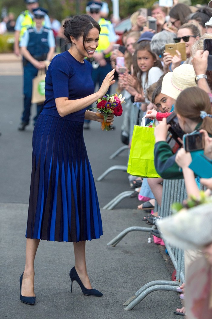 Selama mengandung, Meghan seringkali terlihat stylish di segala kesempatan. Seperti saat ia berkunjung ke Rotorua, New Zealand, pada tahun 2018 lalu Meghan terlihat manis dengan paduan pleated skirt biru tua dari Givenchy dan heels berwarna senada. (Foto: harpersbazaar.com)