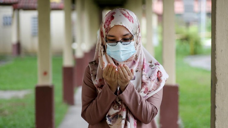 A female adult is putting both hands together for 'doa' (Muslim way of praying) during partial lockdown in Malaysia.