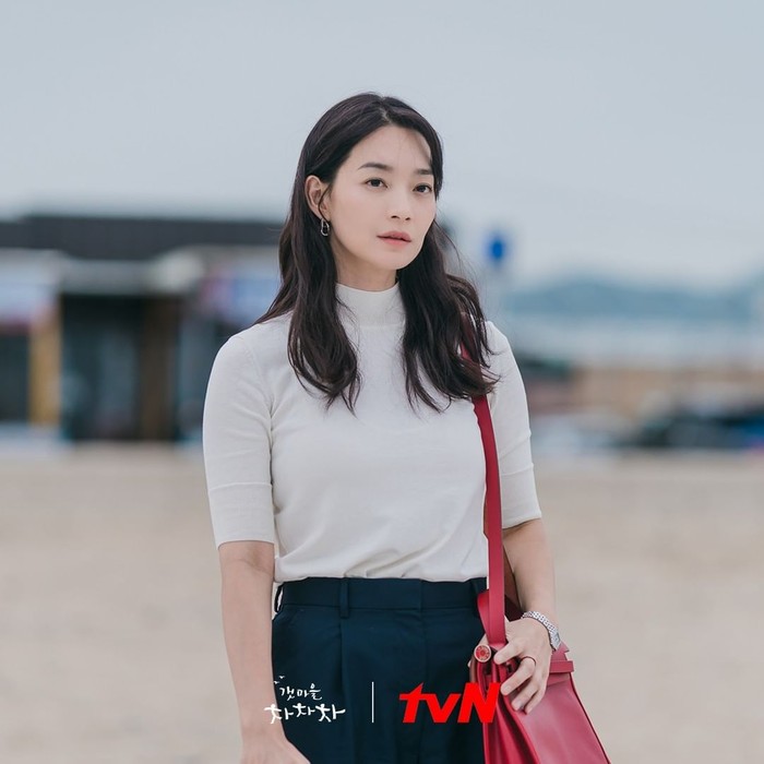 Potret Shin Min Ah tampil dengan fashion simpel turtle neck putih dengan bawahan berwarna biru dipakai ketika ia mengunjungi desa Gongjin untuk pertama kalinya, kala mengingat momen bersama dengan mendiang kedua orang tuanya./Foto: instagram.com/netflixid