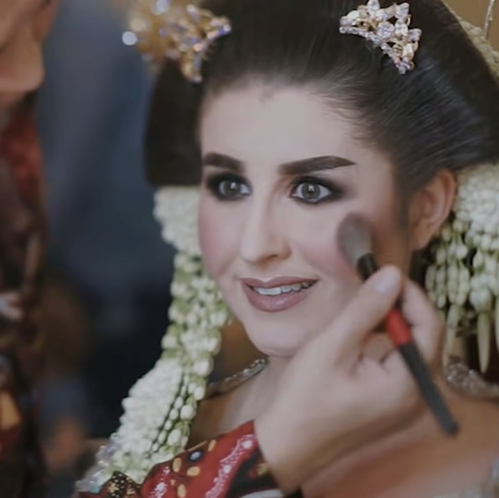 <p>Di hari bahagia itu, Tess tampil cantik ketika dirias menjadi pengantin Jawa. Ia tampil manglingi dengan riasan khas pengantin Indonesia. Penampilannya semakin anggun dengan rambut yang disanggul dan dilengkapi memakai ronce melati. (Foto: YouTube Tess & Tom)</p>