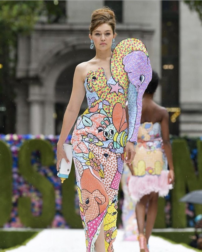 Hadirkan eksplorasi warna pada koleksinya, Moschino menggandeng Gigi Hadid sebagai model dengan membawa botol bayi. Aksinya menggigit botol bayi di tengah runway jadi hal menarik lainnya dari show rumah mode Italia ini. Foto: instagram.com/moschino