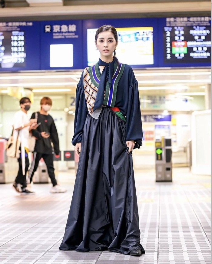 Rok panjang menyapu lantai memberikan nuansa dramatis dari look yang cenderung sederhana ini. Di sisi lain, scarf satin yang tersemat memberikan sentuhan elegan untuk penampilan. Foto: instagram.com/tokyofashion