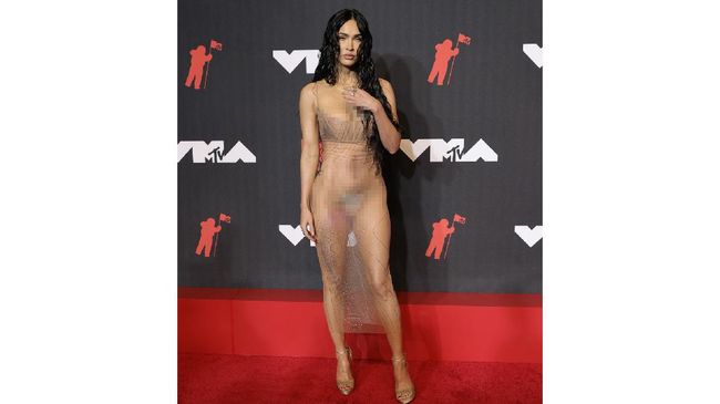 Di perhelatan MTV VMA 2021, Megan Fox hadir bersama kekasihnya Machine Gun Kelly, tampil nyaris telanjang dengan gaun transparannya.