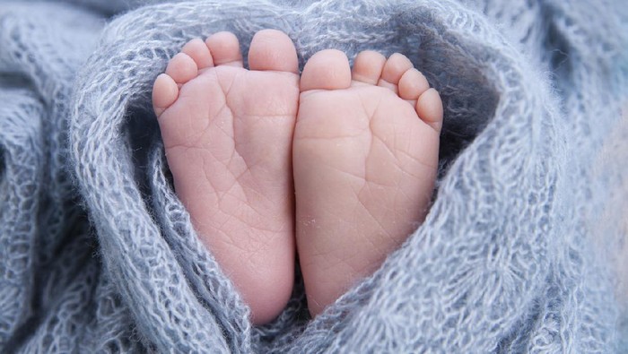 Little toes, baby feet wrapped in a heart blanket