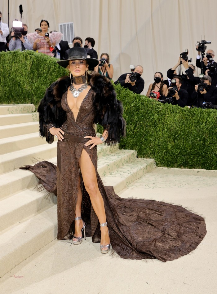 Jennifer Lopez mengenakan gaun dalam rona earth tone dengan aksesori topi rancangan Ralph Lauren.Foto: Getty Images