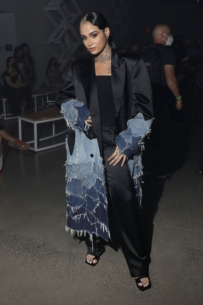 Kehlani terlihat stylish saat menghadiri peragaan desainer Christian Cowan dengan mengenakan coat hitam dengan detail jeans di bagian bawahnya. /Foto: nydailynews.com/Michael Loccisano