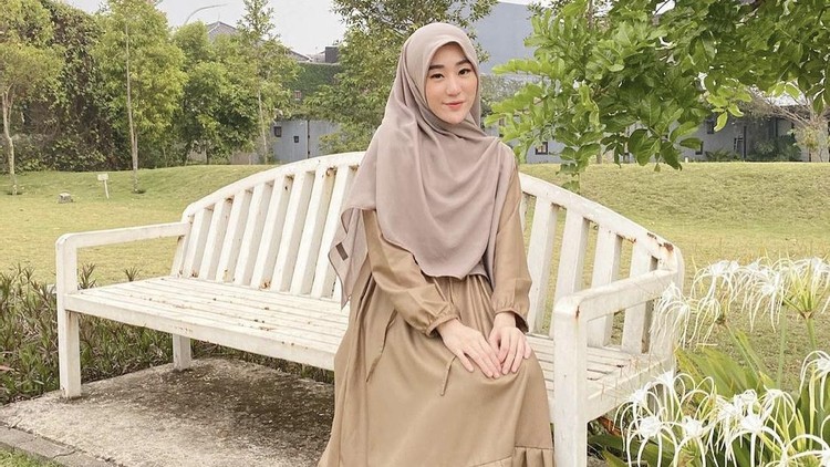 Larissa Chou yang memakai outfit serba earth tone.