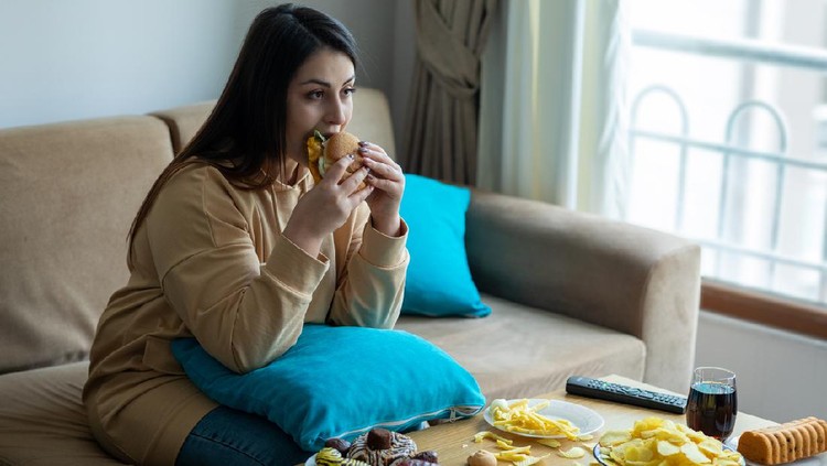 Overweight woman sitting on sofa