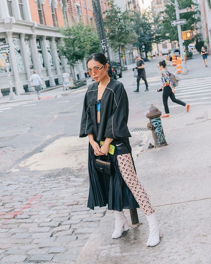 Bukan Ayla Dimitri kalau tidak fashionable. Dengan outfit serba hitam, ia tampil berani dengan rok aksen slit, dipadukan dengan stoking dan boots berwarna putih. (@ayladimitri)