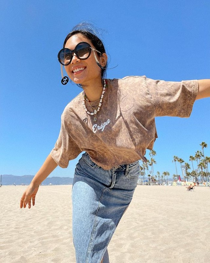 Tampilan yang lebih santai dipakainya saat mengunjungi sebuah pantai di Santa Monica. Ia mengenakan rok denim dan kaus bermotif tie die. Kacamata andalan membuatnya terlihat catchy. Bisa jadi inspirasi outfit liburan nih. (@ayladimitri)