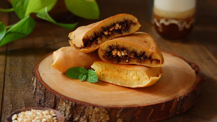 Martabak manis or traditional sweet pancake with various topping on a wooden cutting board
