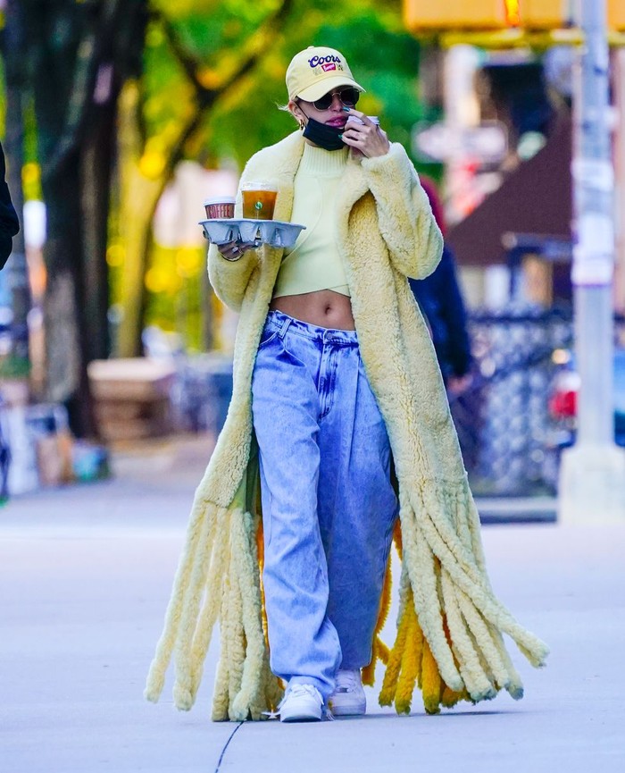 Buying coffee, Hailey stays stylish in a yellow coat from Bottega Veneta teamed with a matching hat, baggy jeans and sneakers/Photo: Getty Images