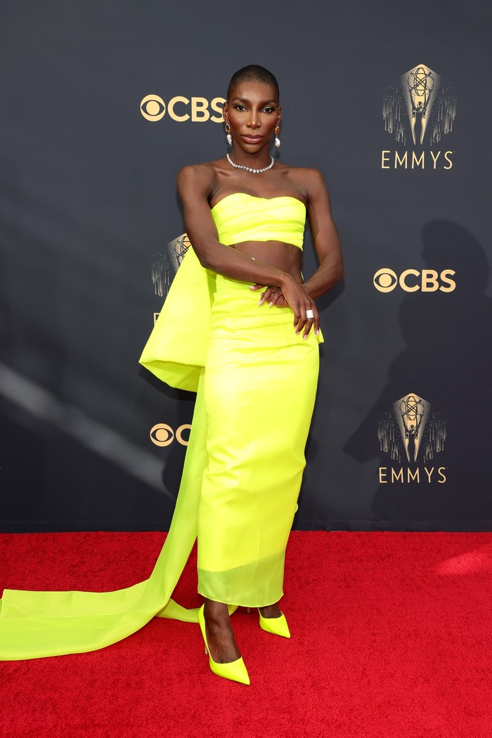 Gaya glamor dalam pulasan warna neon diusung oleh aktris Michaela Coen. Gaun berpotongan crop top dan aksen pita tersebut merupakan rancangan Christopher John Rogers. Foto: Getty Images