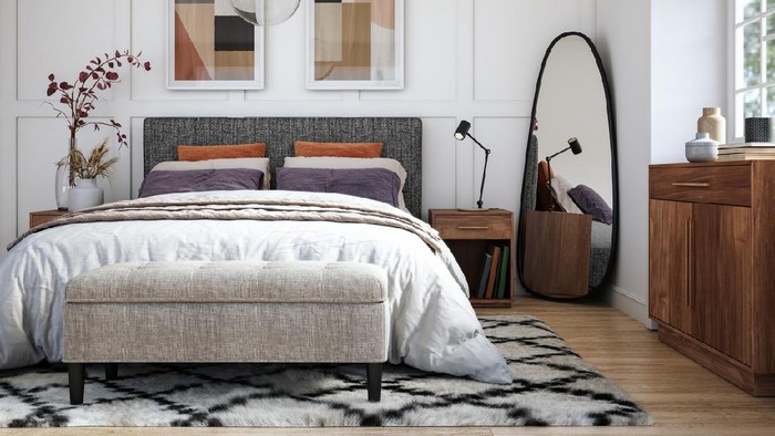 Urban jungle in bedroom with double bed, lamp and carpet, real photo with copy space on the wall