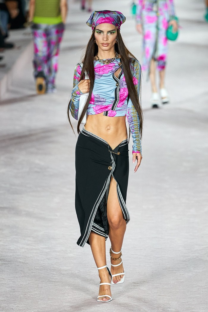 Emily Ratajkowski juga turut berjalan di koleksi terbaru Versace, dengan menganakan busana crop top dan rok asimetris. Foto: Alessandro Lucioni/Go Runway/Vogue