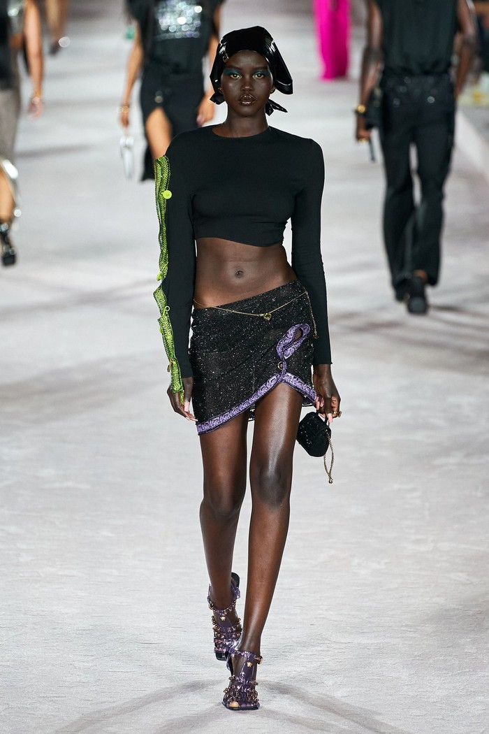 Model Adut Akech kembali tampil di fashion show Versace dalam padanan bernuanas monochrome nan seksi. Foto: Alessandro Lucioni/Go Runway/Vogue