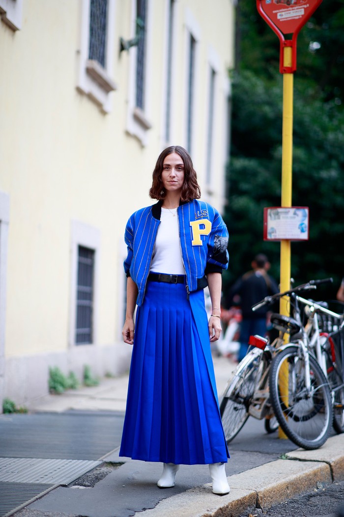Pleats skirt looks sporty thanks to being worn with a matching colored bomber jacket. Forget sneakers, choose boots to make a statement even more. Photo: livingly.com/IMAXtree