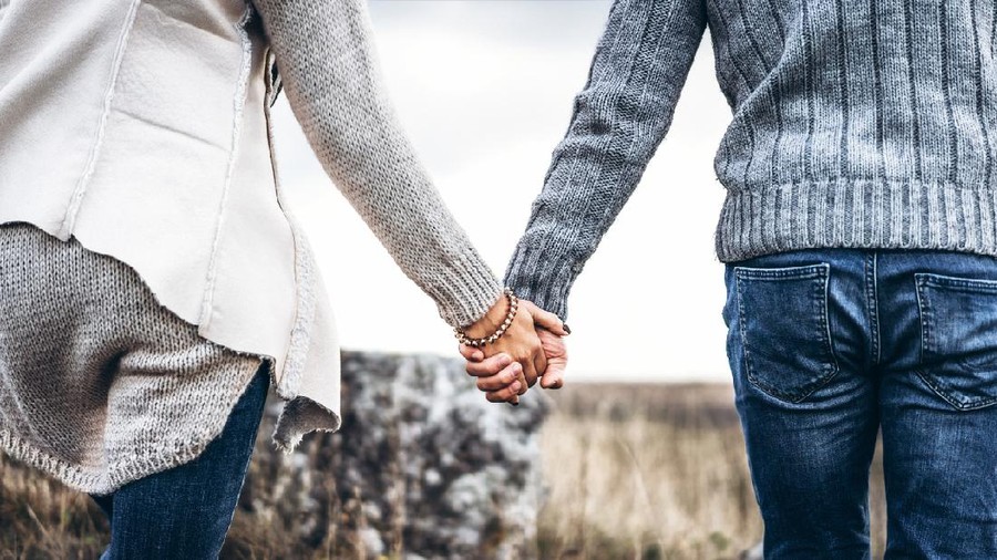 Photo of romatic couple hands, walking outdoor and spending time together