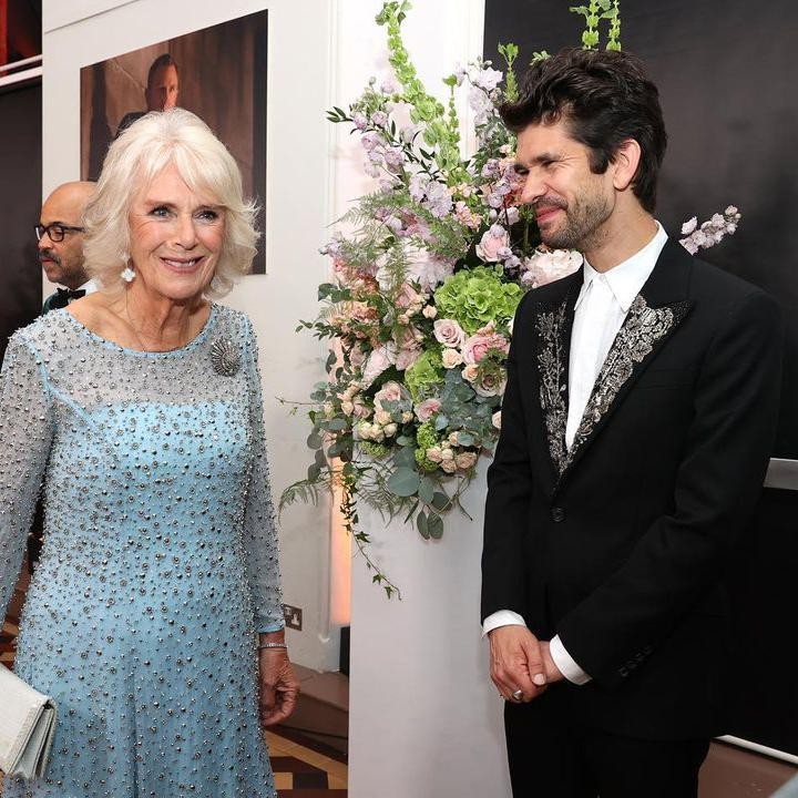 <p>Begitu pula dengan istri Pangeran Charles, Camilla, yang mengenakan gaun biru muda dengan manik-manik hampir di sekujur gaunnya. Ia terlihat antusias menyapa para aktor. (Foto: Instagram @clarencehouse)</p>