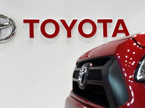 The Toyota logo is displayed beside a pick-up truck on display at a Toyota showroom in Tokyo on February 4, 2016.          AFP PHOTO / TOSHIFUMI KITAMURA (Photo by TOSHIFUMI KITAMURA / AFP)