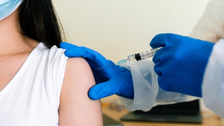 Pendaftaran Vaksin Covid Terdekat: Cara Cek Lokasi Pendaftaran Doctors wearing PPE uniforms white gloves are inoculating the arm muscles to prevent COVID 19.